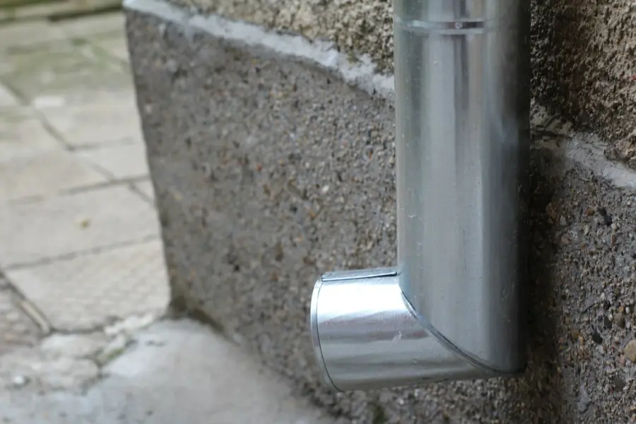 Metal downspout against a masonry wall