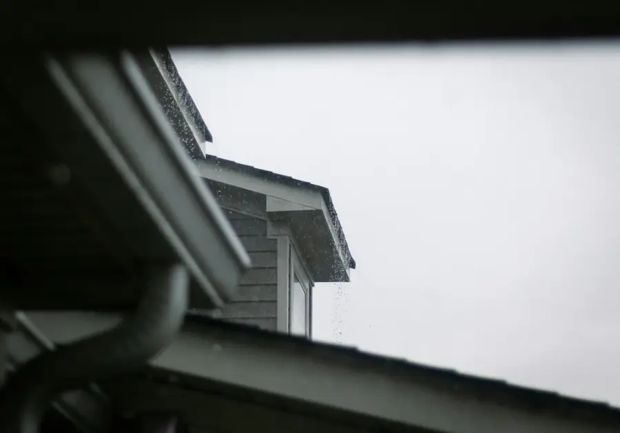 Gutter and downspout along a house roofline