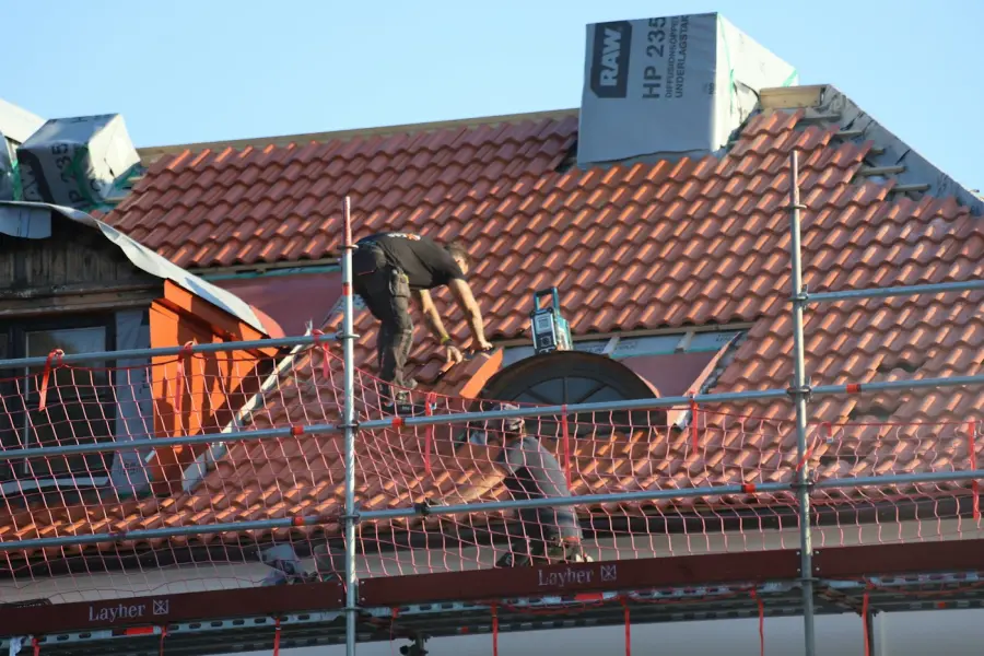 Crew working on a tiled roof from scaffolding