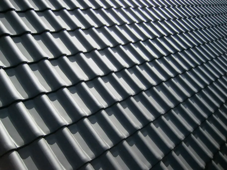 Grey interlocking roof tiles in raking light